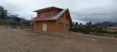 a small wooden house on the side of a dirt road at Cabañas de casa hospedaje Mirador l in Oxapampa