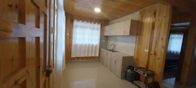 a kitchen with white cabinets and a sink and a window at Cabañas de casa hospedaje Mirador l in Oxapampa