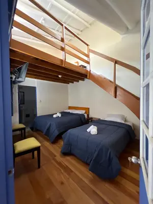 two beds in a room with two at Departamento 1 Waynapata Centro Histórico de Cusco in Cusco
