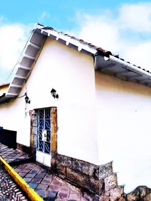 a white house with a window and a roof at Departamento 1 Waynapata Centro Histórico de Cusco in Cusco