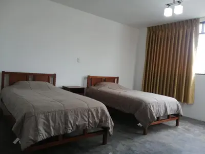 two beds sitting in a room with a window at Casa Extremadura in Lima