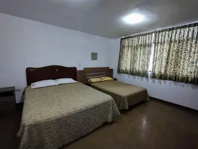 a bedroom with two beds and a window with curtains at Casa Extremadura in Lima
