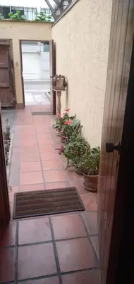a hallway with potted plants and a door at Habitación A1 Trabajar Kitchenette y baño privado in Lima