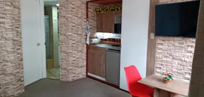 a kitchen with a table and a red chair at Habitación A1 Trabajar Kitchenette y baño privado in Lima