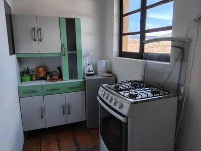 a kitchen with a stove and white cabinets and a window at Apartment in the historic center of Cusco in Cusco