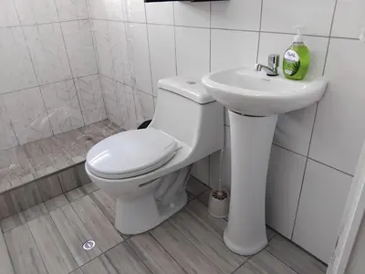a white bathroom with a toilet and a sink at Apartment in the historic center of Cusco in Cusco