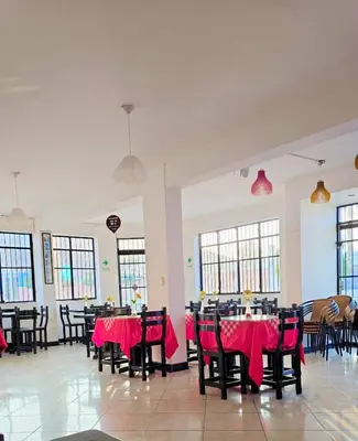 a dining room with tables and chairs with red table cloth at Hostal COSTA AZZURRA in Cerro Azul