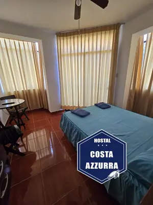 a hotel room with a bed with a sign on it at Hostal COSTA AZZURRA in Cerro Azul
