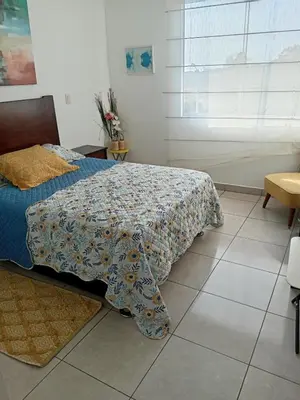 a bedroom with a bed with a blanket on it at Departamento de playa in Asia