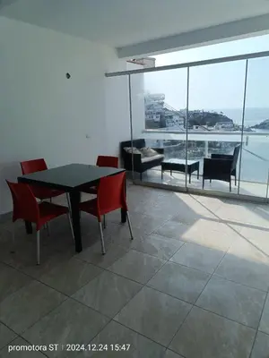 a dining room with a table and chairs and a view of the ocean at departamento frente al mar in San Bartolo