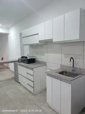 a kitchen with white cabinets and a sink at Mirador del sur in San Bartolo