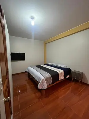 a bedroom with a bed and a television in it at 2da Habitacion a 1 cuadra de la Plaza in Oxapampa