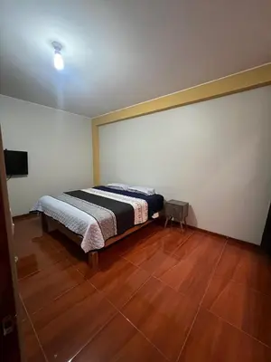 a bedroom with a bed and a wooden floor at 2da Habitacion a 1 cuadra de la Plaza in Oxapampa