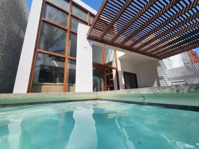 a house with a swimming pool in front of a building at Casa de Playa Familiar in Puerto Viejo