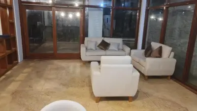 a living room with white furniture and windows at Casa de Playa Familiar in Puerto Viejo