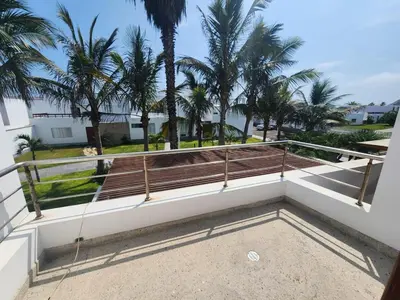 a balcony with a bench and palm trees at Casa de Playa Familiar in Puerto Viejo