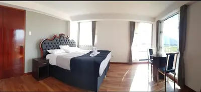 a bedroom with a large bed with a large window at Casa isaaleya in Cusco