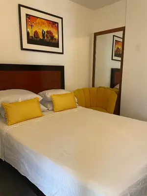 a bedroom with a large white bed with yellow pillows at Hermoso Departamento en el mejor sector de Ica in Ica