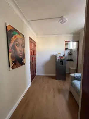 a living room with a painting of a black woman on the wall at Mini Apartment ARES in Lima