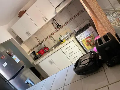 a kitchen with white cabinets and a black bag on the counter at Family Home Furnished Centro Chincha Alta in Chincha Alta