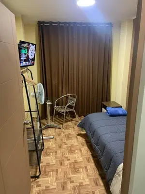 a bedroom with a bed and a chair and a television at Family Home Furnished Centro Chincha Alta in Chincha Alta
