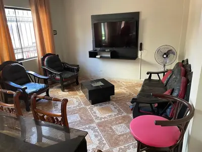 a living room with chairs and a flat screen tv at Family Home Furnished Centro Chincha Alta in Chincha Alta