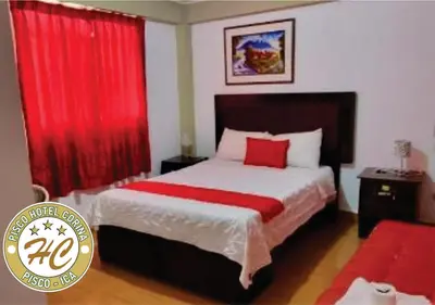 a bedroom with a large bed with red curtains at Pisco Hospedaje Corina in Pisco