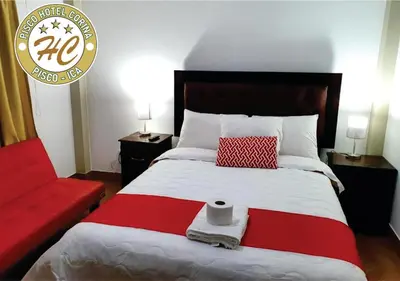 a bedroom with a large bed and a red couch at Pisco Hospedaje Corina in Pisco