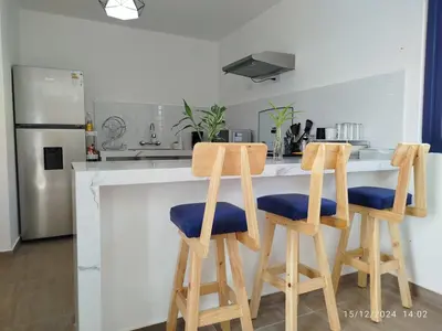a kitchen with two wooden stools at a kitchen counter at CASA DE PLAYA FRENTE AL MAR k173 in San Vicente de Cañete