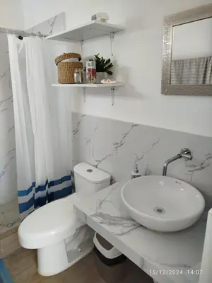 a white bathroom with a sink and a toilet at CASA DE PLAYA FRENTE AL MAR k173 in San Vicente de Cañete