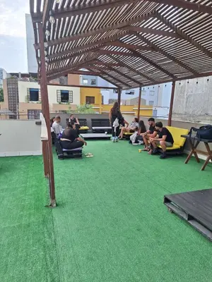 a group of people sitting in chairs under a roof at Hostel rivendell lima in Lima