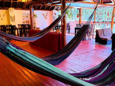 a hammock in a room with tables and chairs at Andenes del Inca Hotel in Ollantaytambo