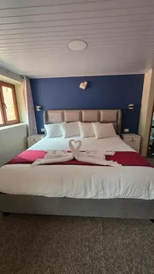a bedroom with a large bed with a blue wall at Andenes del Inca Hotel in Ollantaytambo