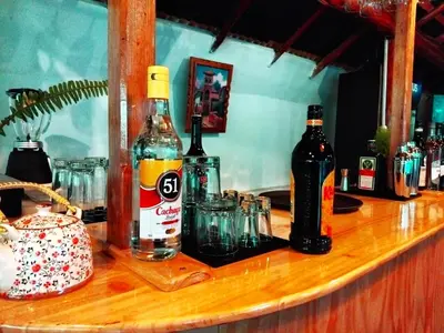 a bar with bottles and glasses on a wooden counter at Andenes del Inca Hotel in Ollantaytambo