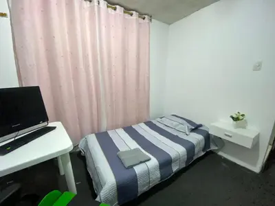 a bedroom with a bed and a desk with a computer at Habitación con baño particular, lindas áreas comunes in Lima
