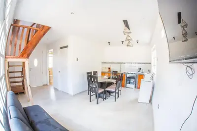 a living room and kitchen with a table and chairs at Edelweiss Haus in Chontabamba