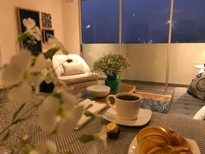 a living room with a table with a cup of coffee at Moderno Dpto , Equipado, Céntrico, Vista Increible in Lima