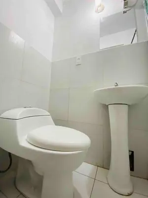 a white bathroom with a toilet and a sink at Minidepartamento La Molina Junin 1 in Lima