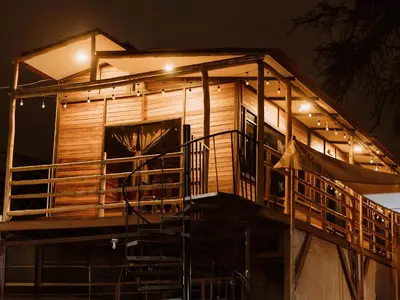 a tree house with a deck at night at HOSPEDAJE CasaBlanca Huacachina in Ica