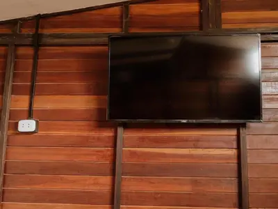 a flat screen tv hanging on a wooden wall at HOSPEDAJE CasaBlanca Huacachina in Ica