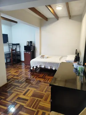 a bedroom with a bed and a wooden floor at Amplia habitación independiente con baño privado in Lima
