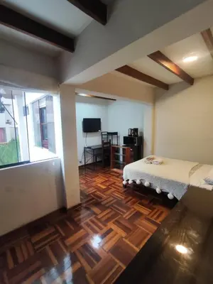 a bedroom with a bed and a wooden floor at Amplia habitación independiente con baño privado in Lima