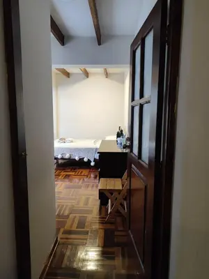 a room with a bed and a table and a door at Amplia habitación independiente con baño privado in Lima