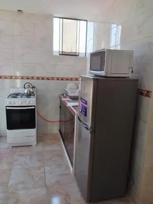 a kitchen with a microwave on top of a refrigerator at Nice stay in Los Olivos in Lima