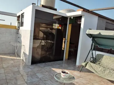 a balcony with a glass door and a table at Nice stay in Los Olivos in Lima