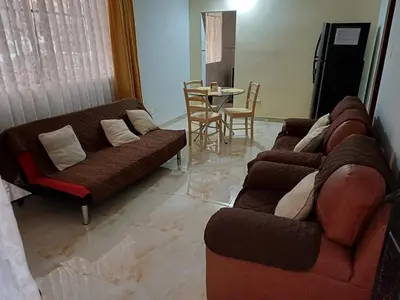 a living room with couches and a table and a dining room at Family accommodation in Lima