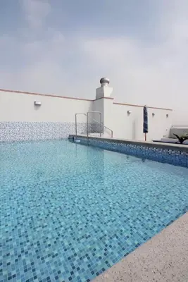 a large swimming pool with blue tiles in a building at Vista piloto cerca Miraflores y Centro Histórico, seguridad 24 h in Lima