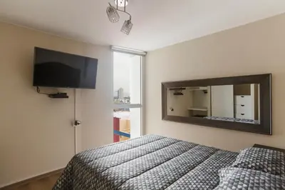 a bedroom with a bed and a large mirror at Vista piloto cerca Miraflores y Centro Histórico, seguridad 24 h in Lima