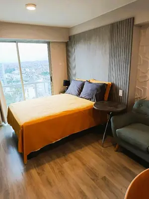 a bedroom with a large bed and a chair at LA POSADA DE GUILLE - JAVIER PRADO Este 1501 in Lima