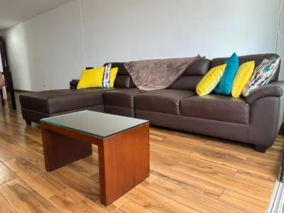 a brown couch with pillows and a table in a living room at El Derby 511 Apart 2 Dorm con Aire Acondicionado in Lima